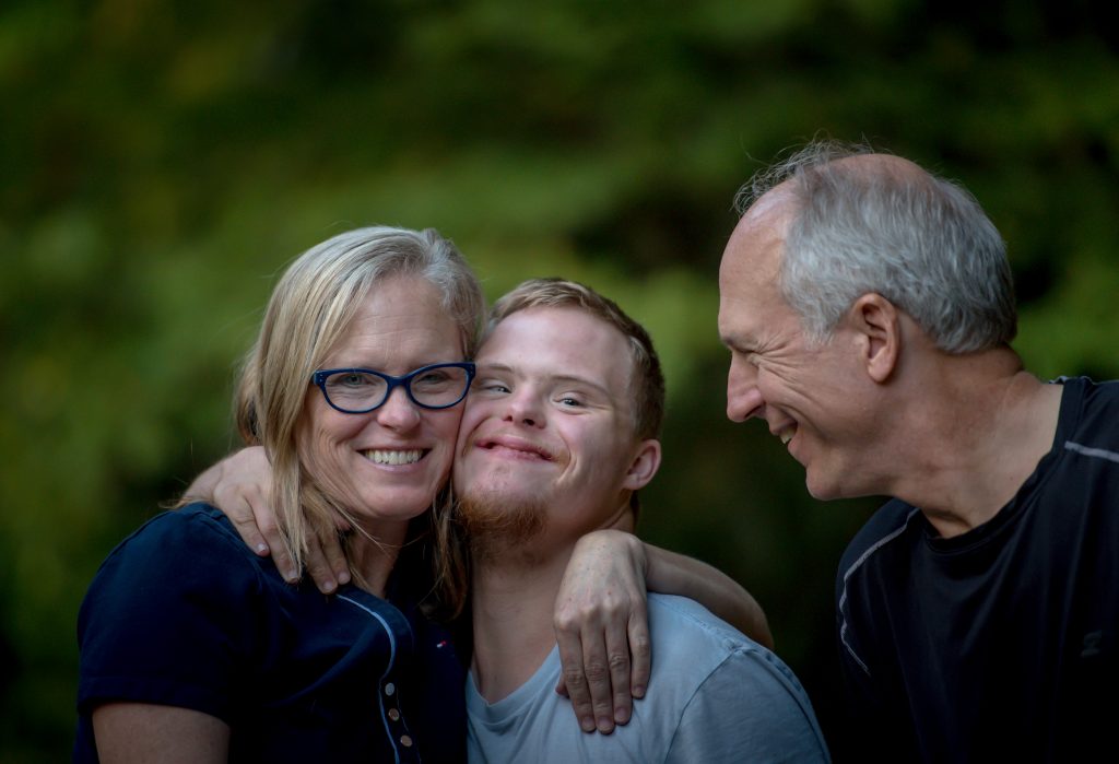 Mother, son, and father smiling and embracing